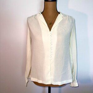 White and cream button-up blouse with ruffle details and pearl neckline